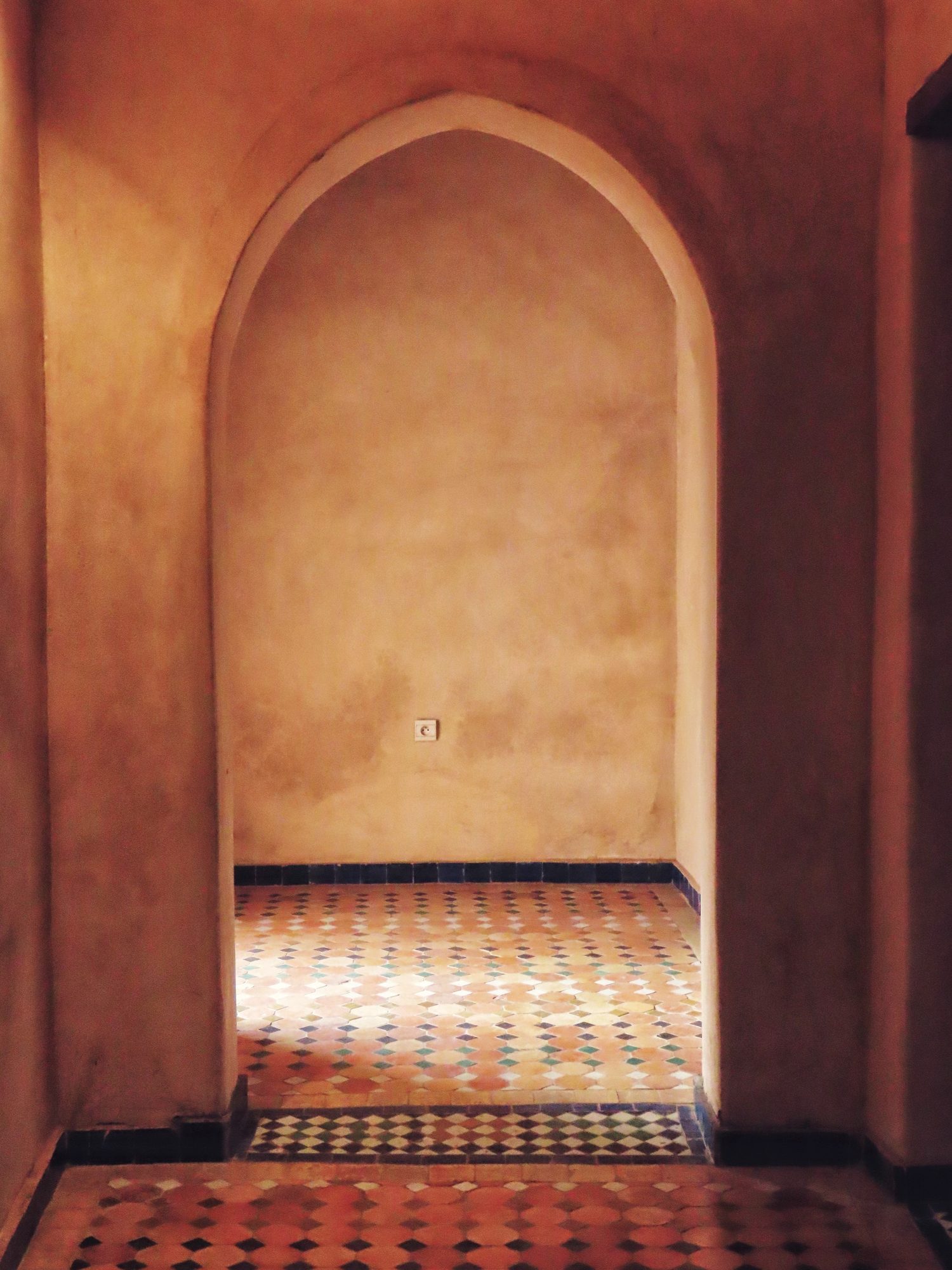 Limewashed arched passage opening onto a terracotta floor