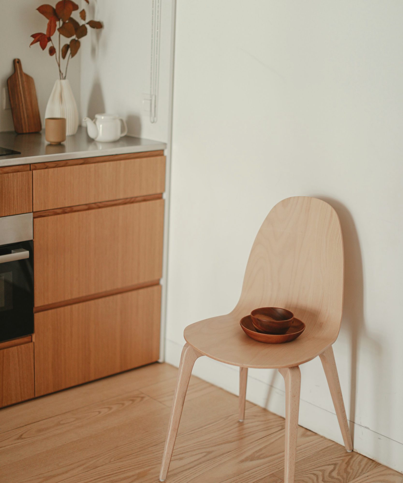 Oak kitchen with a pale timber chair in low morning sun